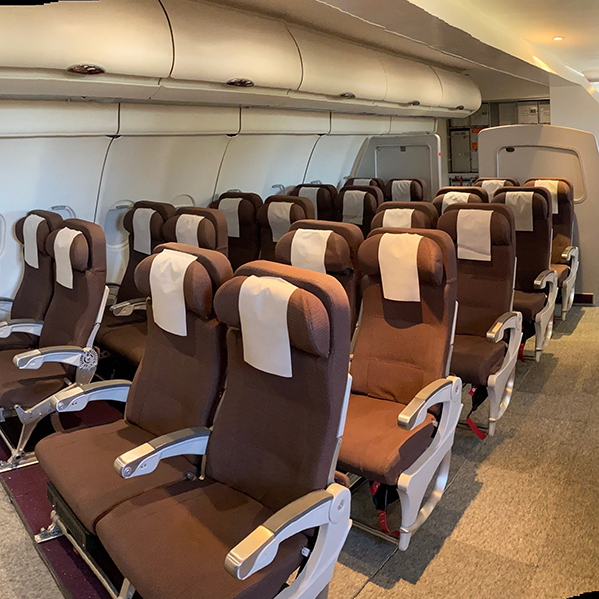 Seating area of Airplane Cabin mock-up, including life jackets, seatbelts, and overhead bins at the RTL Training Facilities.